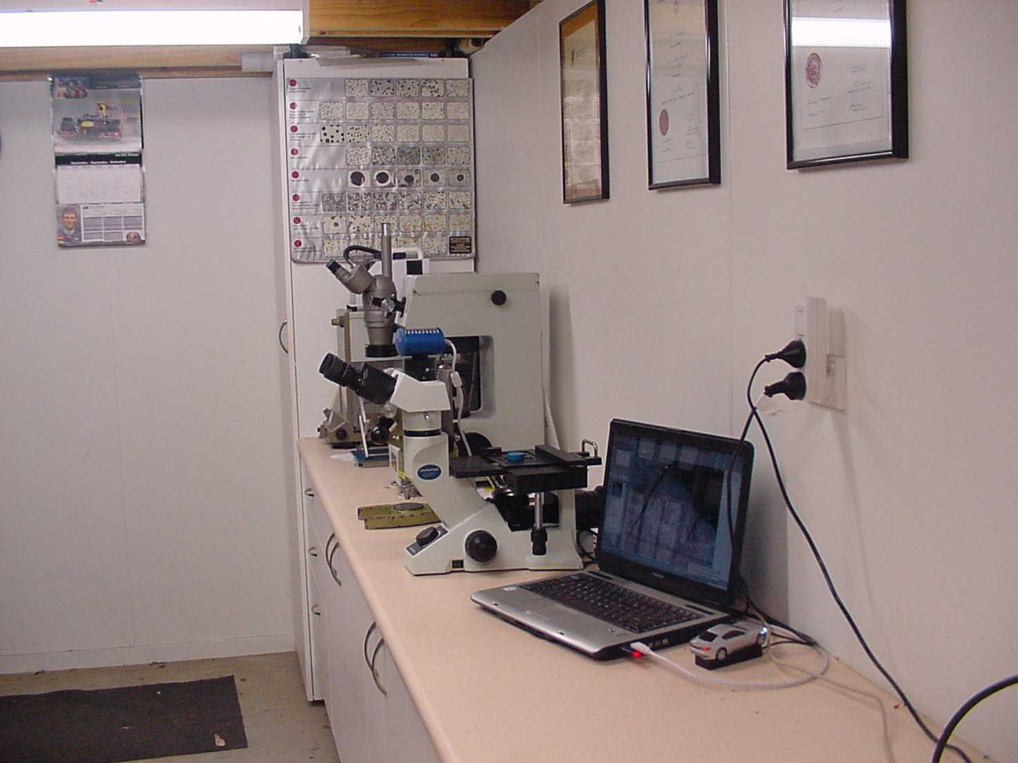 Microscopes, hardness testing equipment and analytical balance in the metalurgical laboratory.